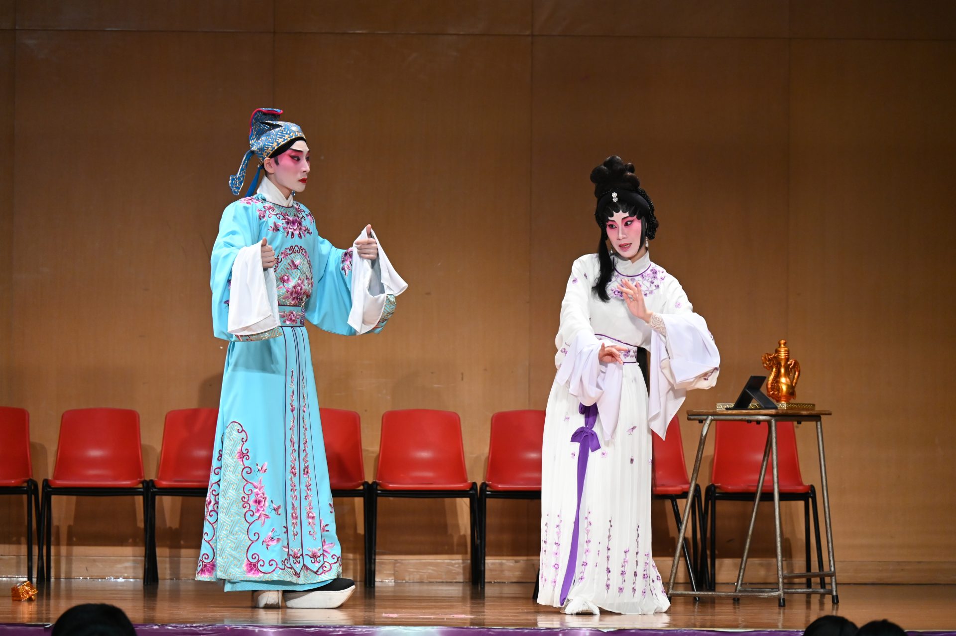 Cantonese Opera Performers singing and acting on stage.