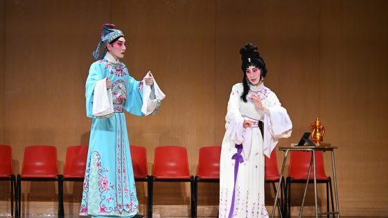 Cantonese Opera Performers singing and acting on stage.