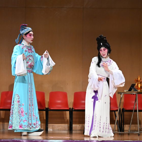 Cantonese Opera Performers singing and acting on stage.
